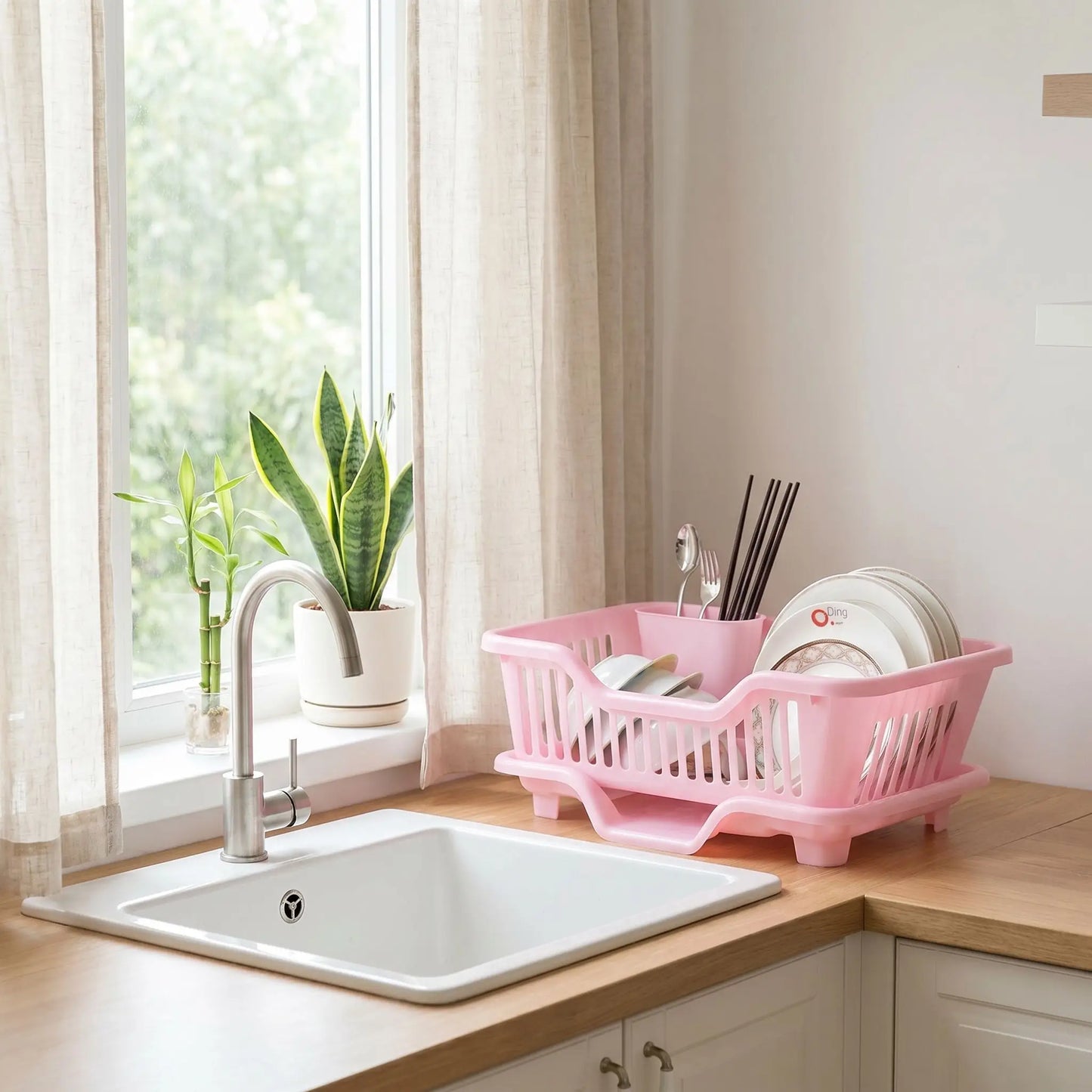 Égouttoir vaisselle drainage automatique rose sur comptoir avec plantes