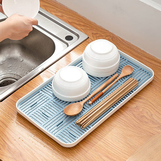 Égouttoir vaisselle plastique bleu sur comptoir près du lavabo