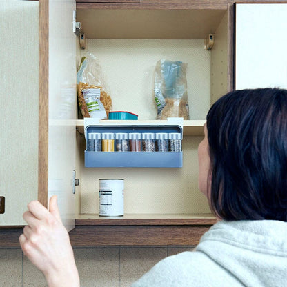 Étagère à épices coulissante sans perçage déployée au maximum dans une armoire beige - femme tenant la porte d'armoire