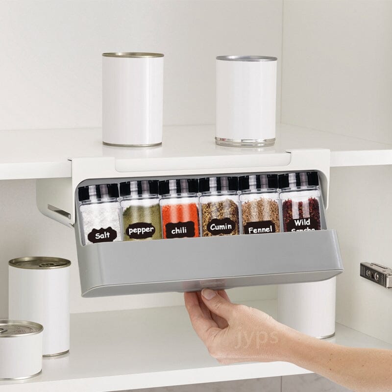 Étagère à épices coulissante sans perçage dans une armoire blanche avec pots d'épices étiquetés