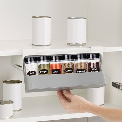 Étagère à épices coulissante sans perçage dans une armoire blanche avec pots d'épices étiquetés