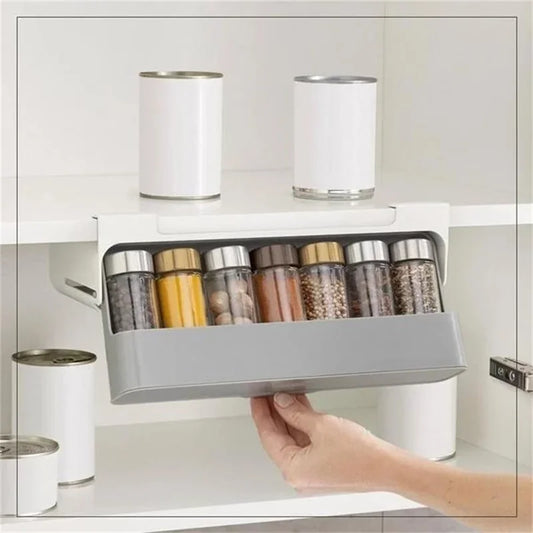 Étagère à épices coulissante sans perçage dans une armoire blanche avec pots d'épices - main humaine tenant l'étagère avec cannes et condiments