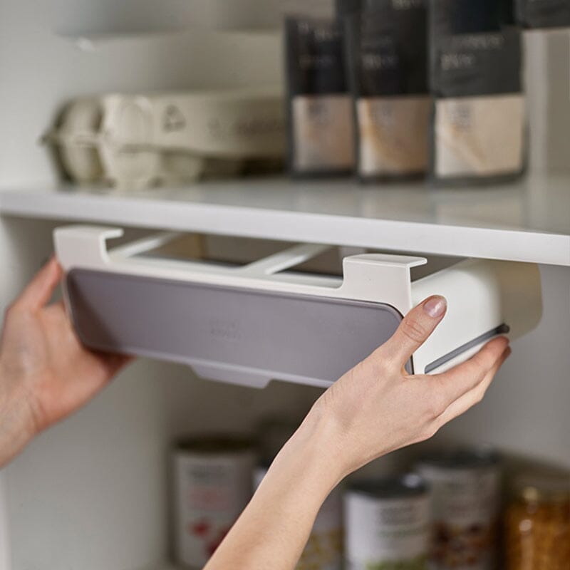 Étagère à épices coulissante sans perçage - démonstration d'installation sur tablette par 2 mains humaines dans une armoire avec cannes et condiments